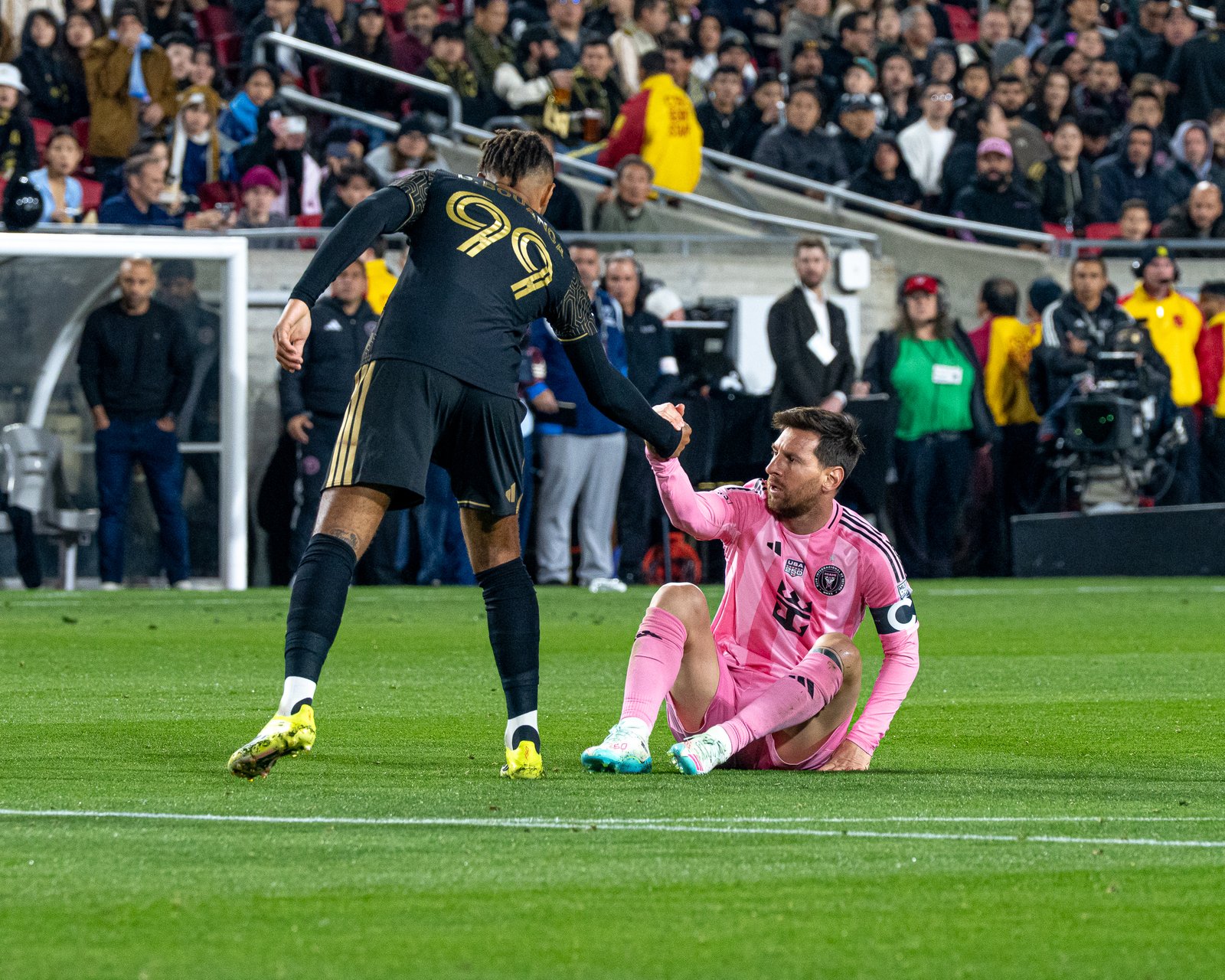 LAFC forward Denis Bouanga helps Lionel Messi up during LAFC vs Inter Miami