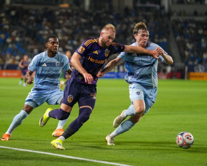 Los Angeles Galaxy striker João Klauss (99) battles for possession with Sporting Kansas City defender Wyatt Meyer (28) during an MLS match at Dignity Health Sports Park in Carson, California on March 14, 2026. – Photo Credit: Angel Almada.