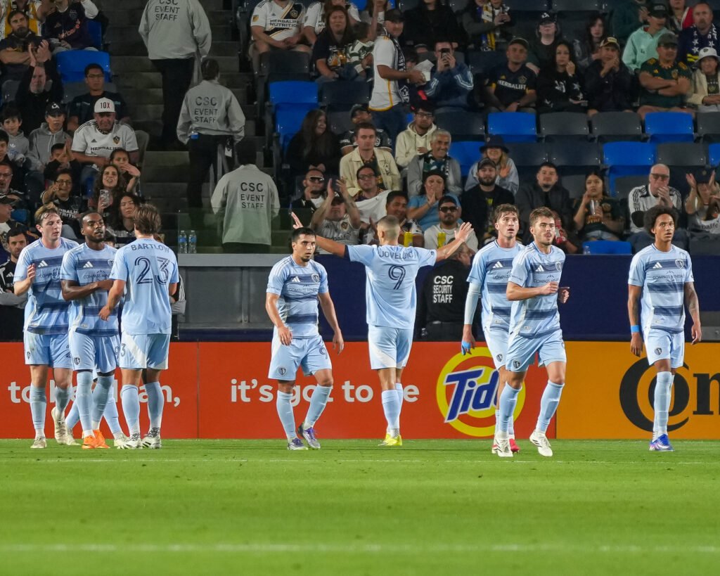 Former LA Galaxy striker Dejan Joveljić celebrates after scoring for Sporting Kansas City against the LA Galaxy during an MLS match at Dignity Health Sports Park, raising his arms toward the crowd following the opening goal. – Photo Credit: Angel Almada