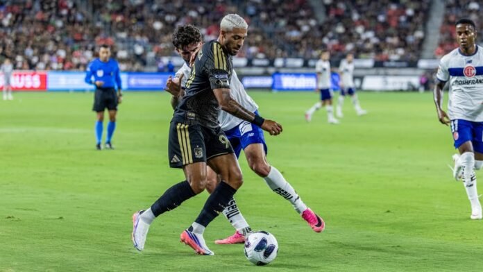 LAFC forward Denis Bouanga shields the ball from a Toluca defender during a match at BMO Stadium.
