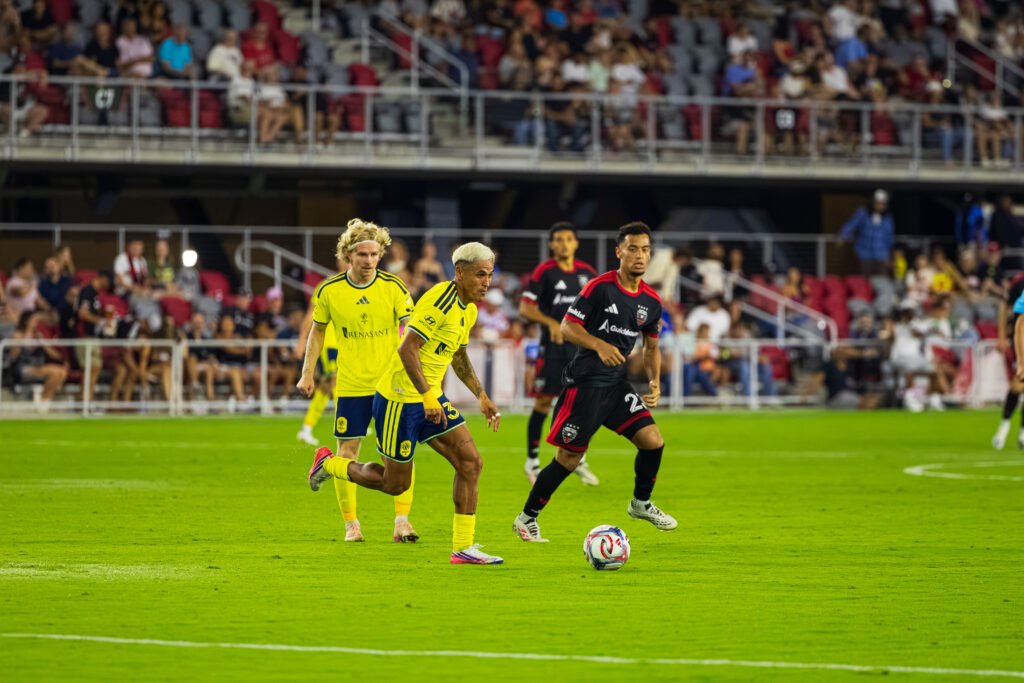 MLS - Nashville SC's Andy Najar pushing through the DC United midfield looking for a open pass with pressure from DC United's B. Servania at Audi Field in Washington DC on Saturday August 1st 2026. Photo Credits: Omar Yair Soto
