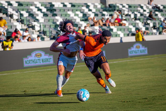 Orange County SC forward Lyam MacKinnon (11) fights through contact from Sacramento Republic defender Ryan Spaulding (3) while advancing the ball on Saturday evening at Championship Soccer Stadium in Irvine, CA - photo by Adrian Perez