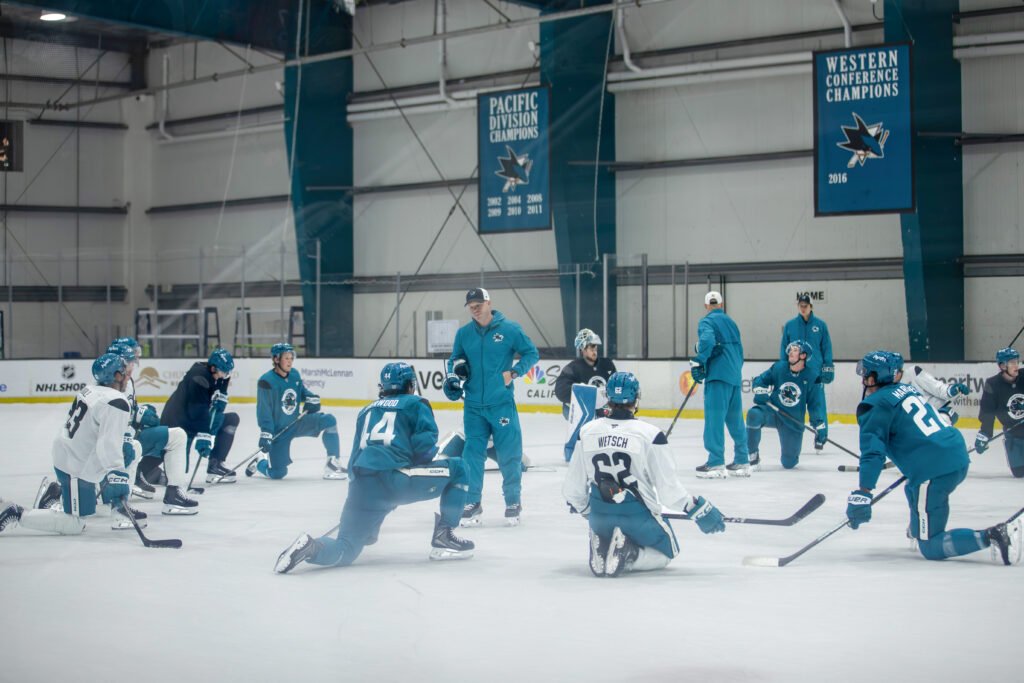 San Jose Sharks assistant coach speaks to players gathered around him during Training Camp at Sharks Ice in San Jose.