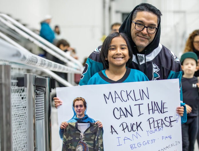 Young San Jose Sharks fan holding a handmade sign asking Macklin Celebrini for a puck during Sharks Training Camp at Sharks Ice in San Jose.