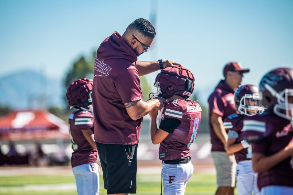 Jose Pagan IV and Father Jose Pegan III preps child before game at Fontana High School - Photos by - Bruno De Witt Zanotto